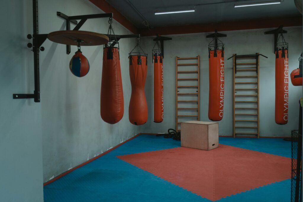 Interior view of a gym with boxing bags and equipment, designed for fitness enthusiasts.