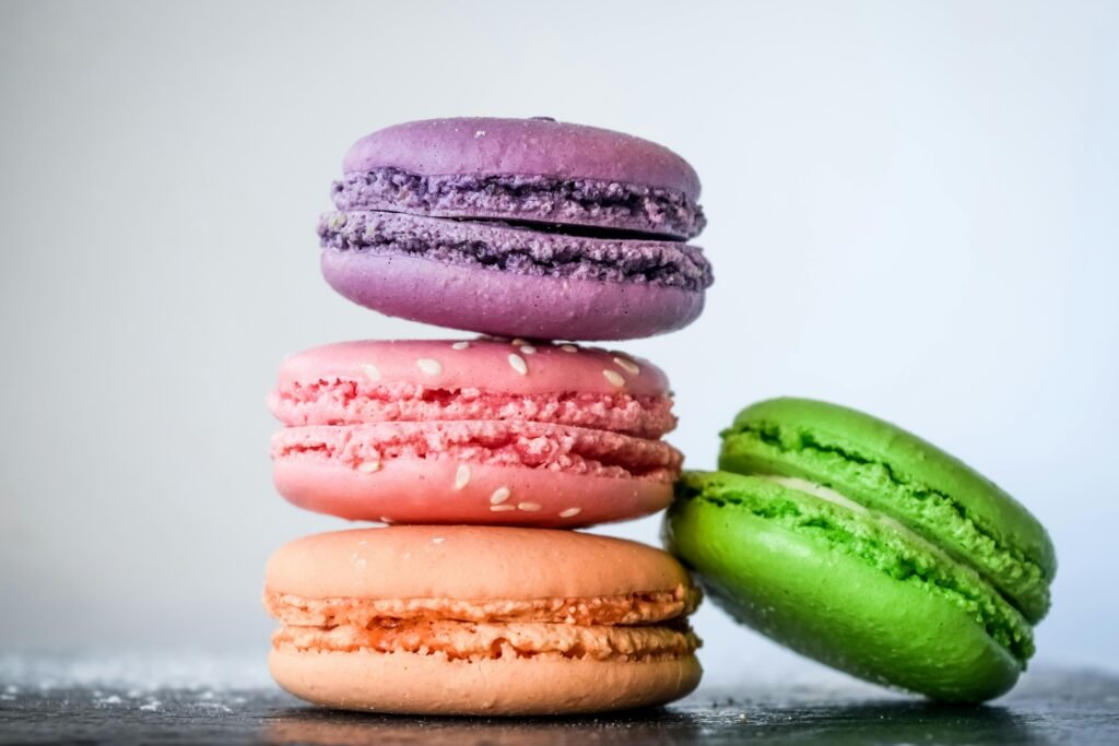 A vibrant stack of colorful macarons with sesame seeds, perfect for dessert lovers.